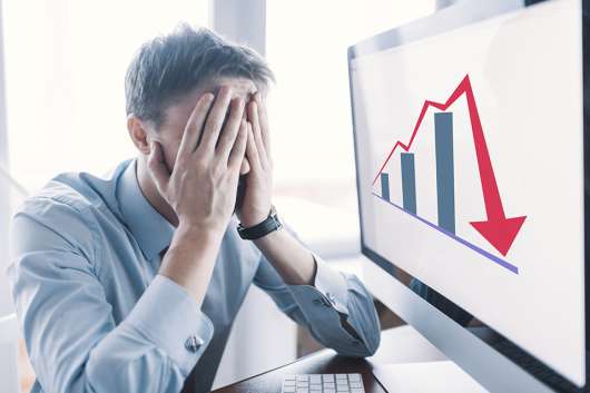 Foto: Gestresste Person und Chart mit Abwärtspfeil 
