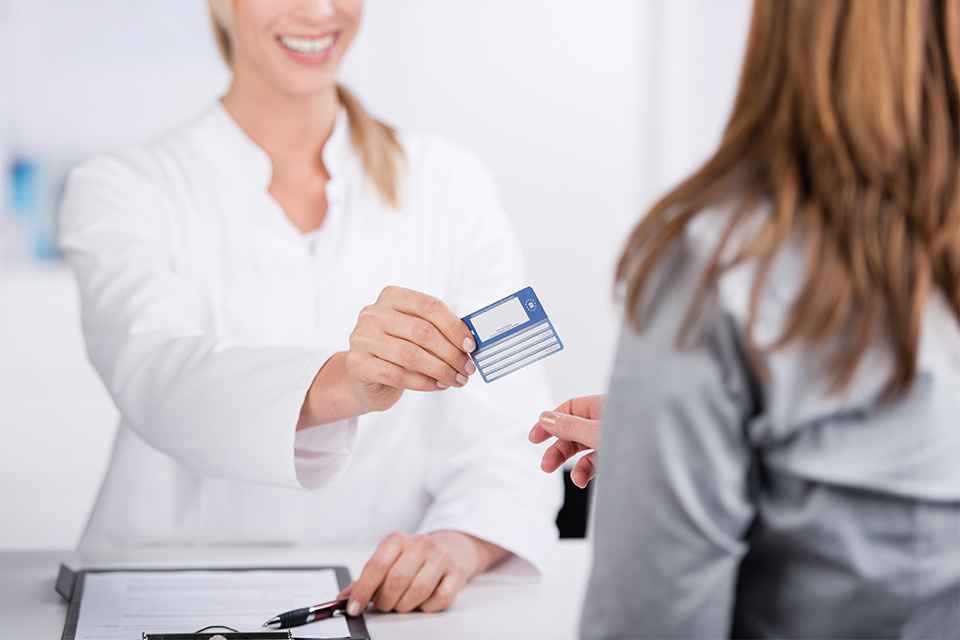 Foto: Patientin und Arzthelferin mit Versicherungskarte 